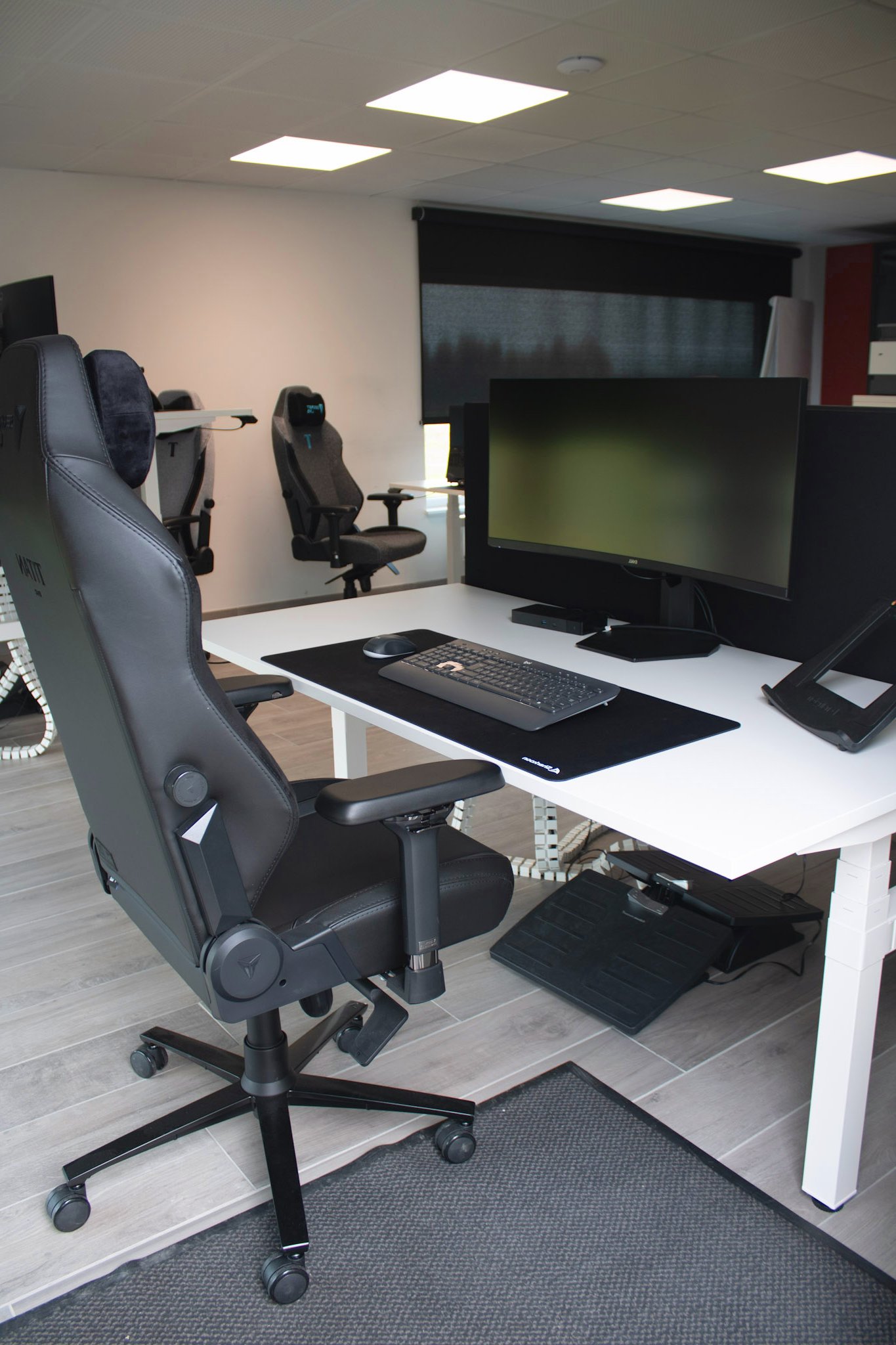 Professioneel ingerichte IT-werkruimte bij Mad IT met dubbele schermen en gaming-stoelen — optimale werkomgeving voor developers en techteams.