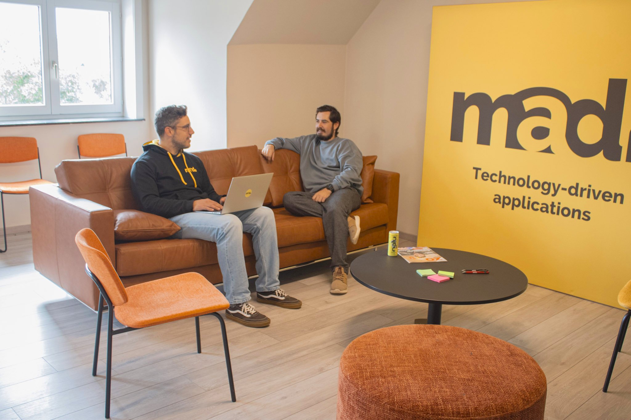 Twee IT-specialisten van Mad IT overleggen in een creatieve kantooromgeving over maatwerk softwareoplossingen – brainstormsessie voor technologiegedreven applicatieontwikkeling.